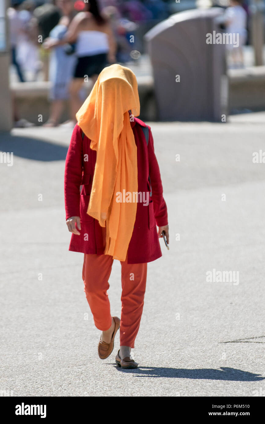 Femme au visage masqué, couvrant le visage avec des foulards, voiles et masques à Blackpool, Lancashire, 1er juillet 2018. UK Météo : ensoleillé jour torride sur la côte comme les amoureux du soleil et les touristes profiter sort sur la plage et promenade du bord de mer Banque D'Images