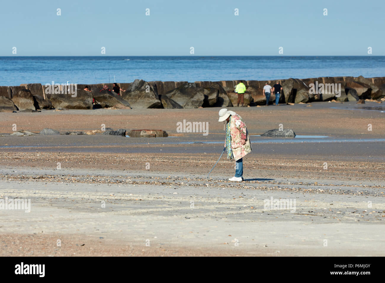 Woman combing la plage de coquillages Banque D'Images