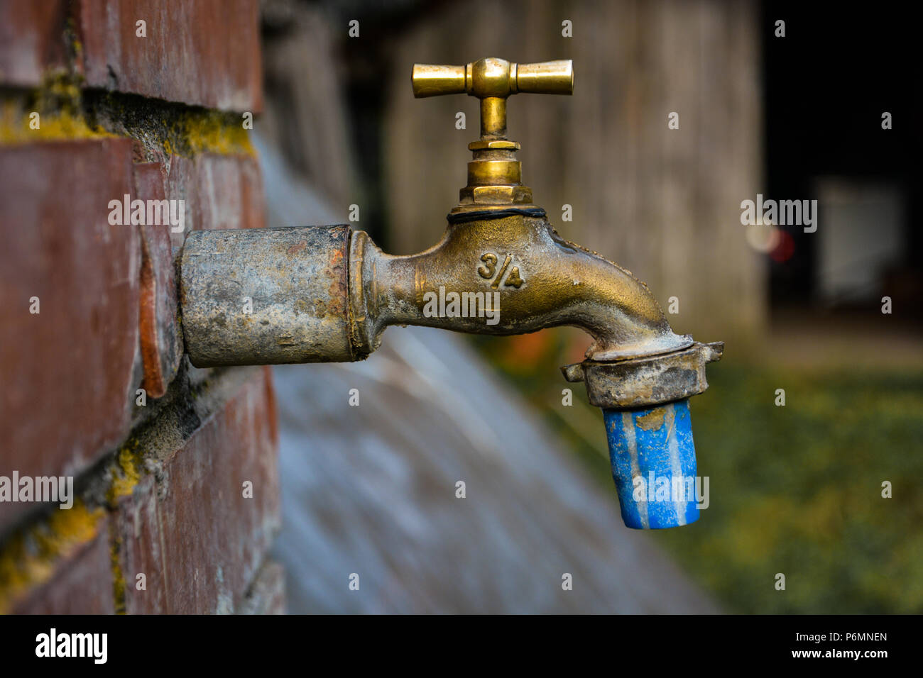 Vieux et utilisé Vintage robinet isolated.de profil métallique bronze,robinet avec un tuyau bleu blanc à la fin et le numéro 3/4 d'un côté et DF sur d'autres. Banque D'Images