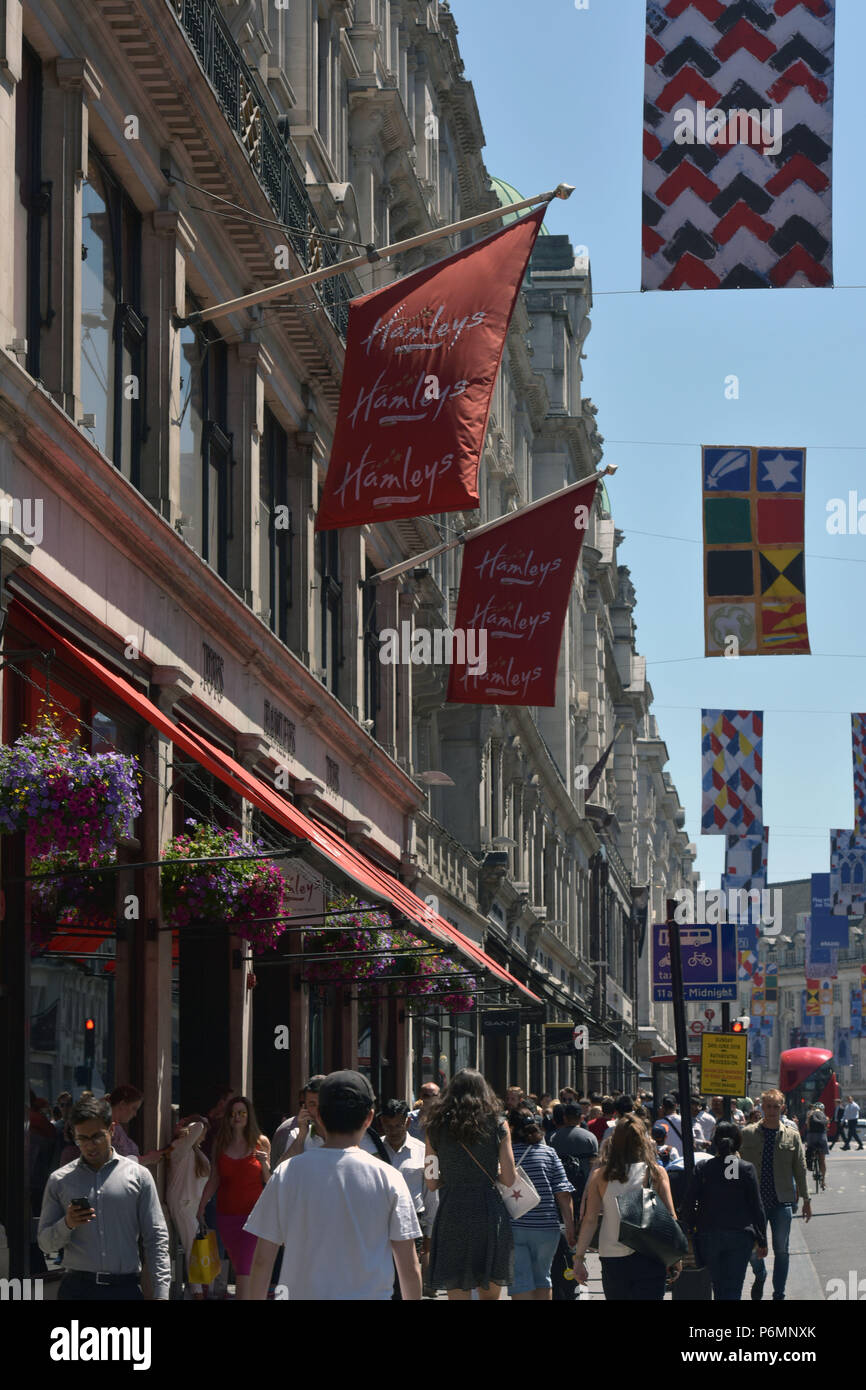 Les consommateurs, les touristes et les employés de bureau passent devant le navire amiral Hamleys toy store sur Regent Street dans le centre de Londres, dans le soleil d'été. Banque D'Images