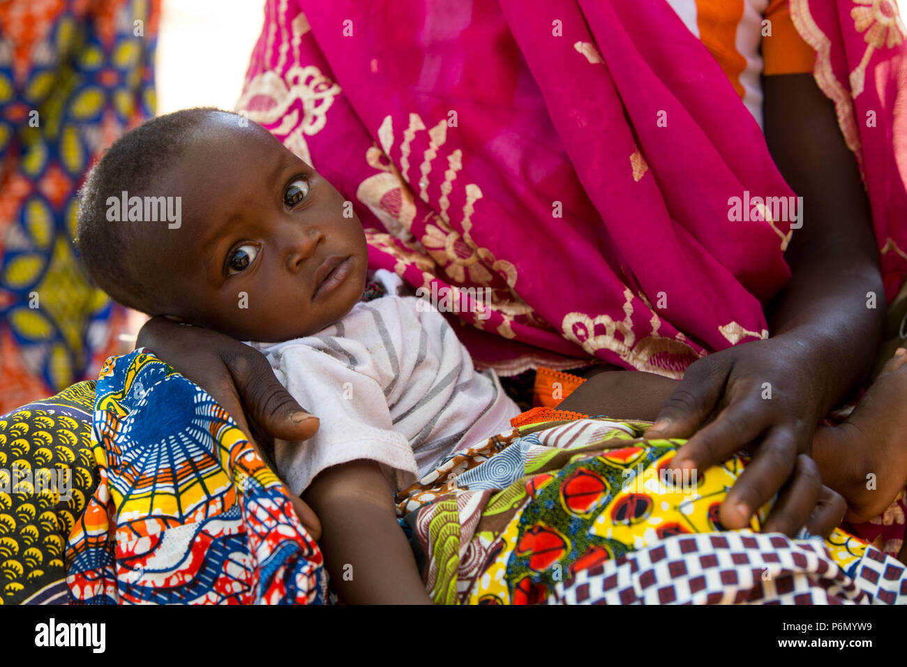 Enfant sur les genoux de sa mère dans le nord du Togo. Banque D'Images