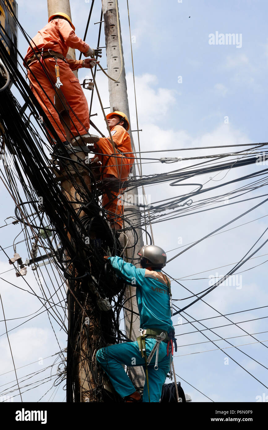 Electrician repairing Maintenance électricité pylône. Cai Be. Le Vietnam. Banque D'Images