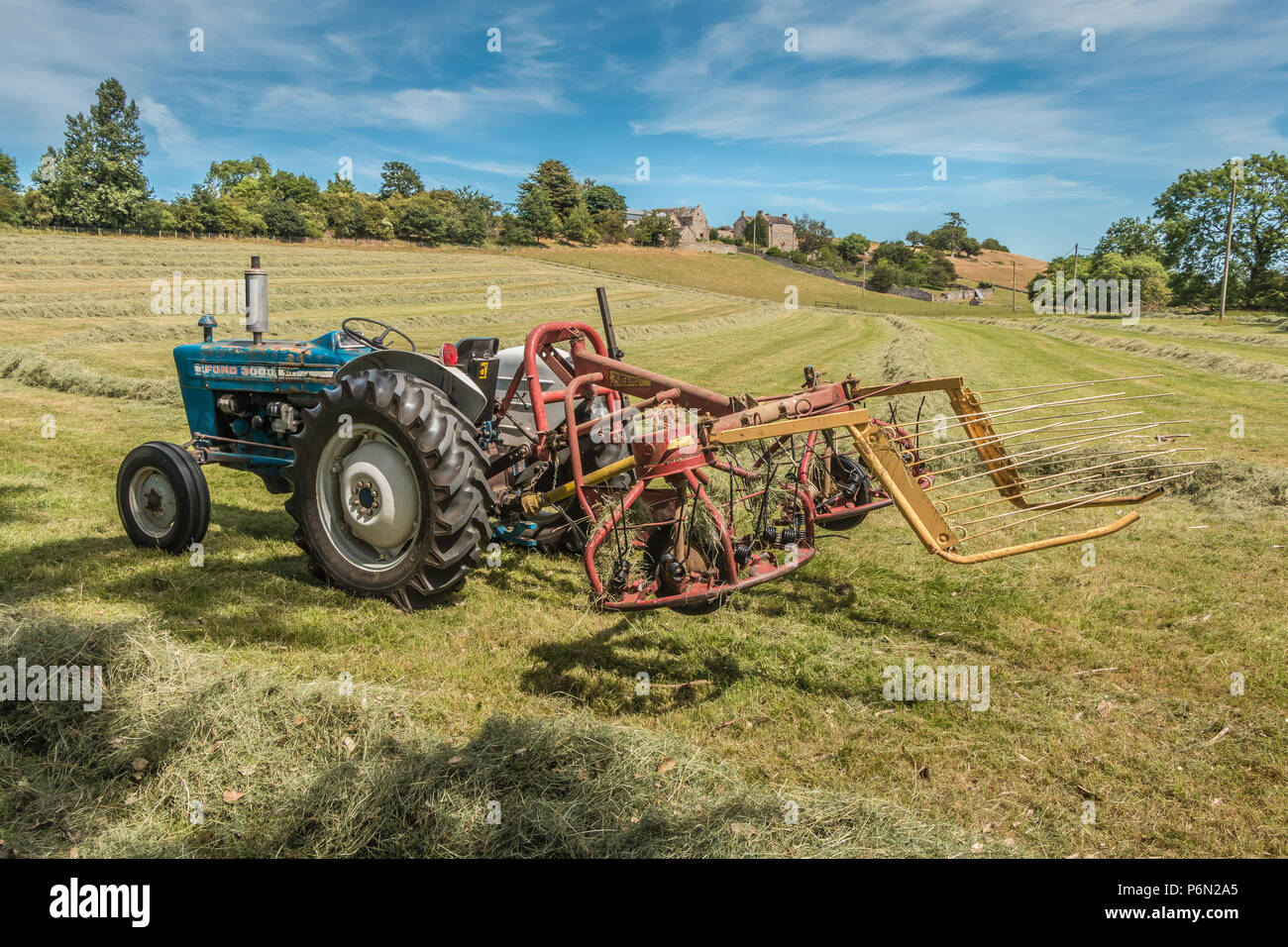 L'agriculture britannique, un millésime 3000 Ford Tracteur et hayrake dans un champ de foin fraîchement retournée prêt pour la mise en balles à West Middleton, ferme, de Teesdale UK Banque D'Images