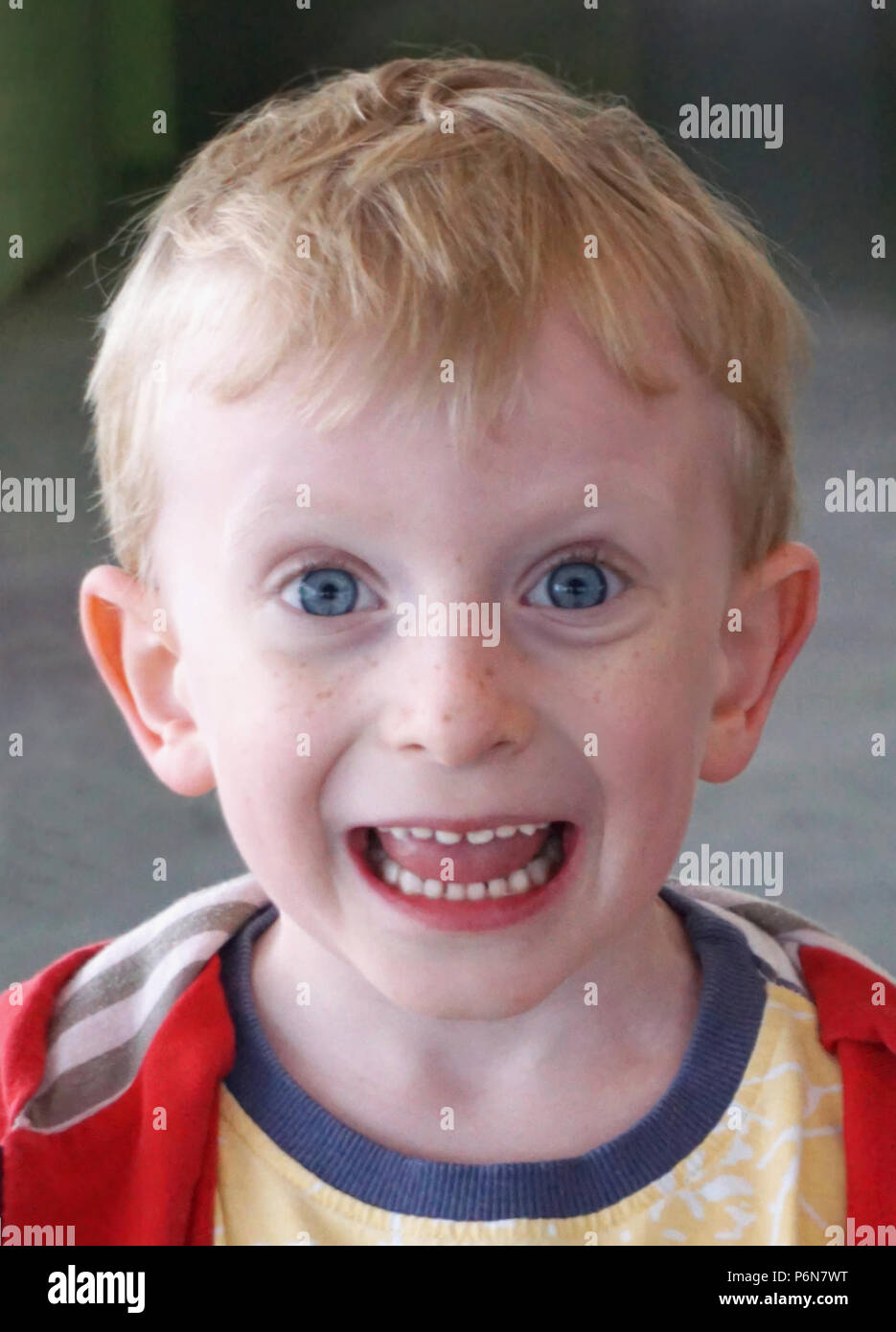 Beau petit garçon aux yeux bleus de 4 ans d'essayer de faire une Drôle de tronche d'expression. Divertissant et amusant les enfants concept portrait Banque D'Images