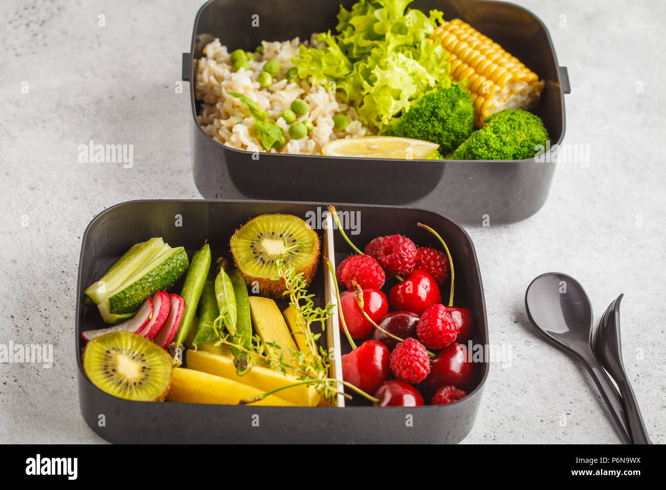 Préparation des repas sains avec des conteneurs de riz brun, le brocoli, les légumes, les fruits et les baies, fond blanc Banque D'Images