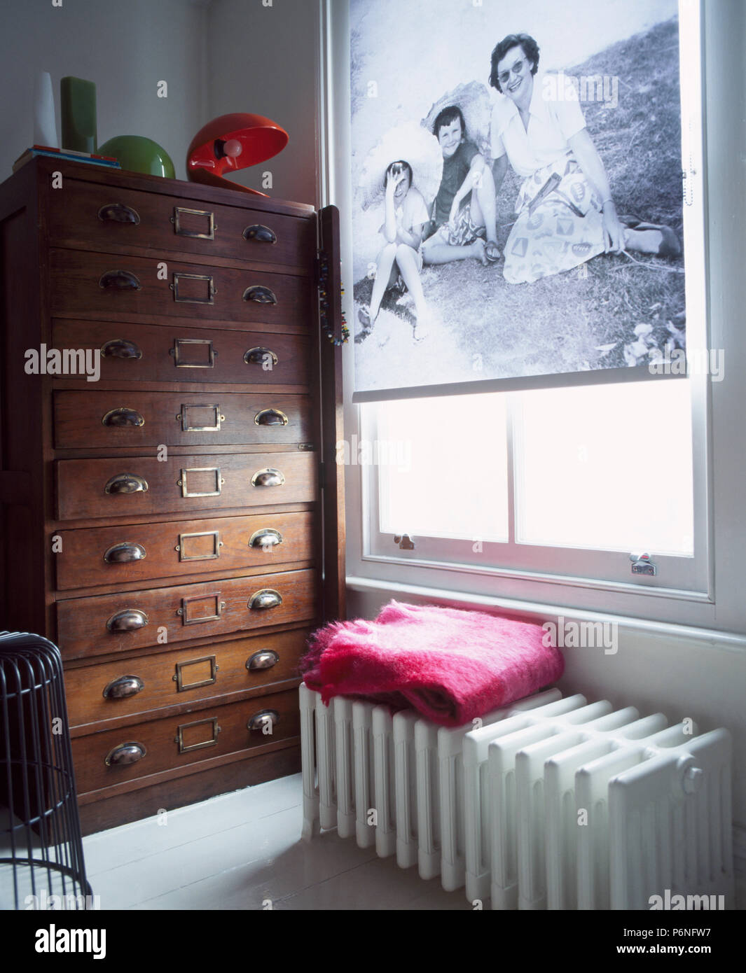 Noir +blanc à motifs-aveugles sur fenêtre au-dessus de gros radiateur en étude avec commode ancienne haut-de-tiroirs Banque D'Images