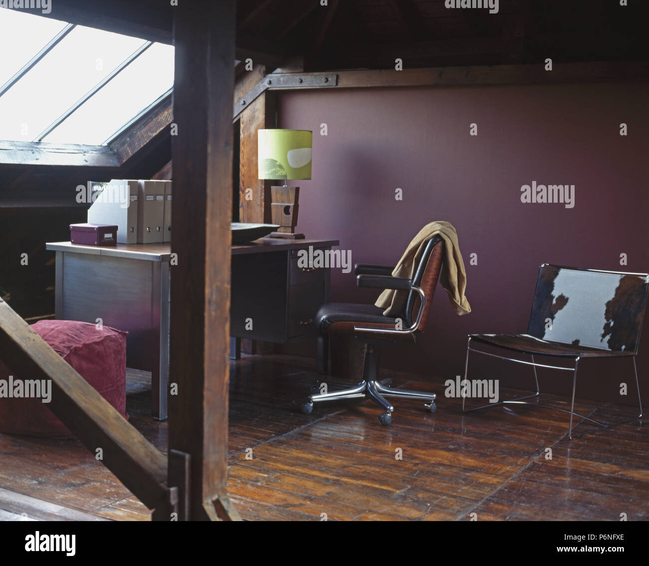 Poulain coussin sur une chaise en cuir violet dans l'étude de conversion loft avec fauteuil pivotant à 24 Banque D'Images