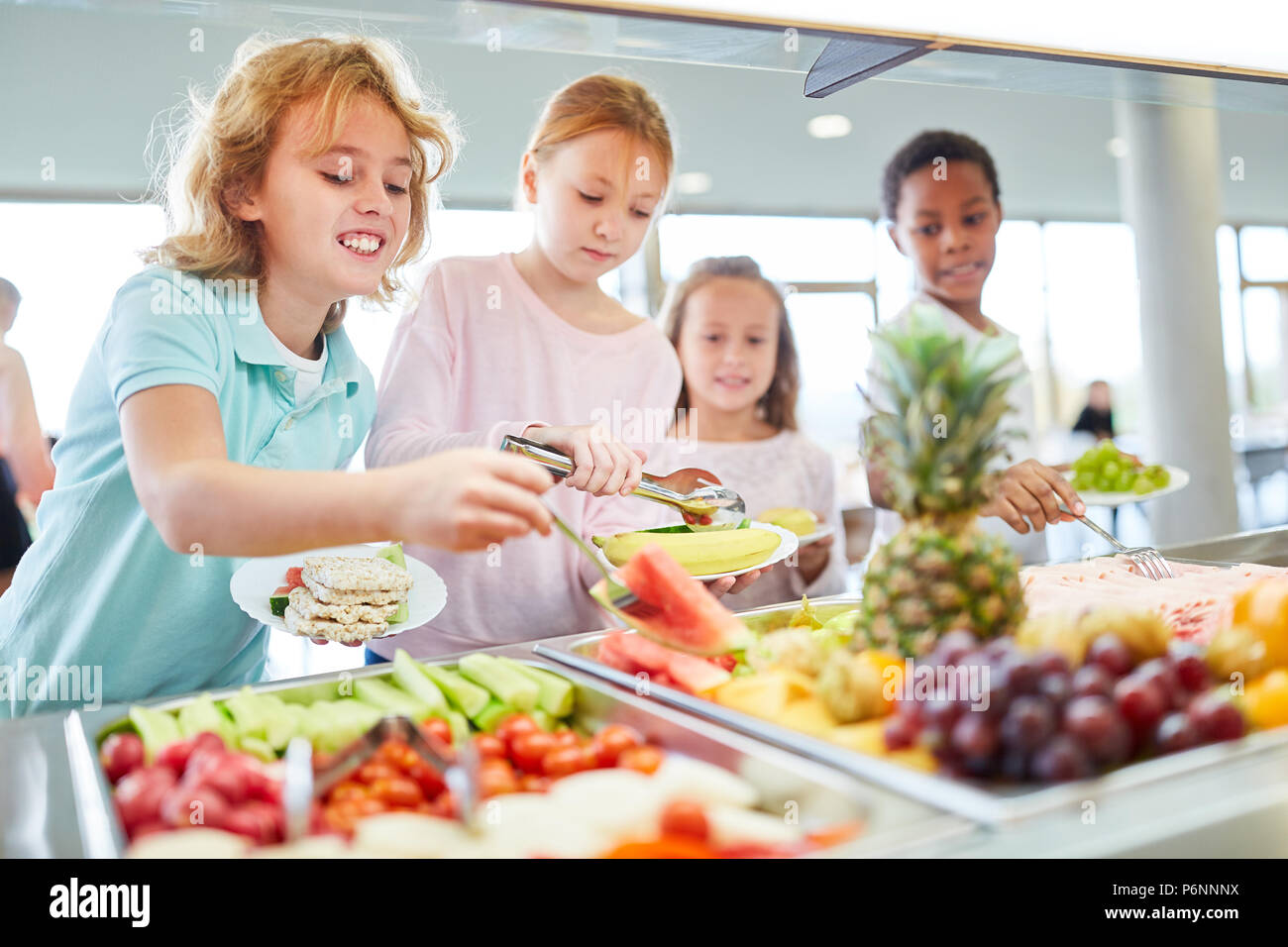 Les enfants qui ont faim en tant qu'étudiants ramasser des fruits à la cafétéria du buffet Banque D'Images