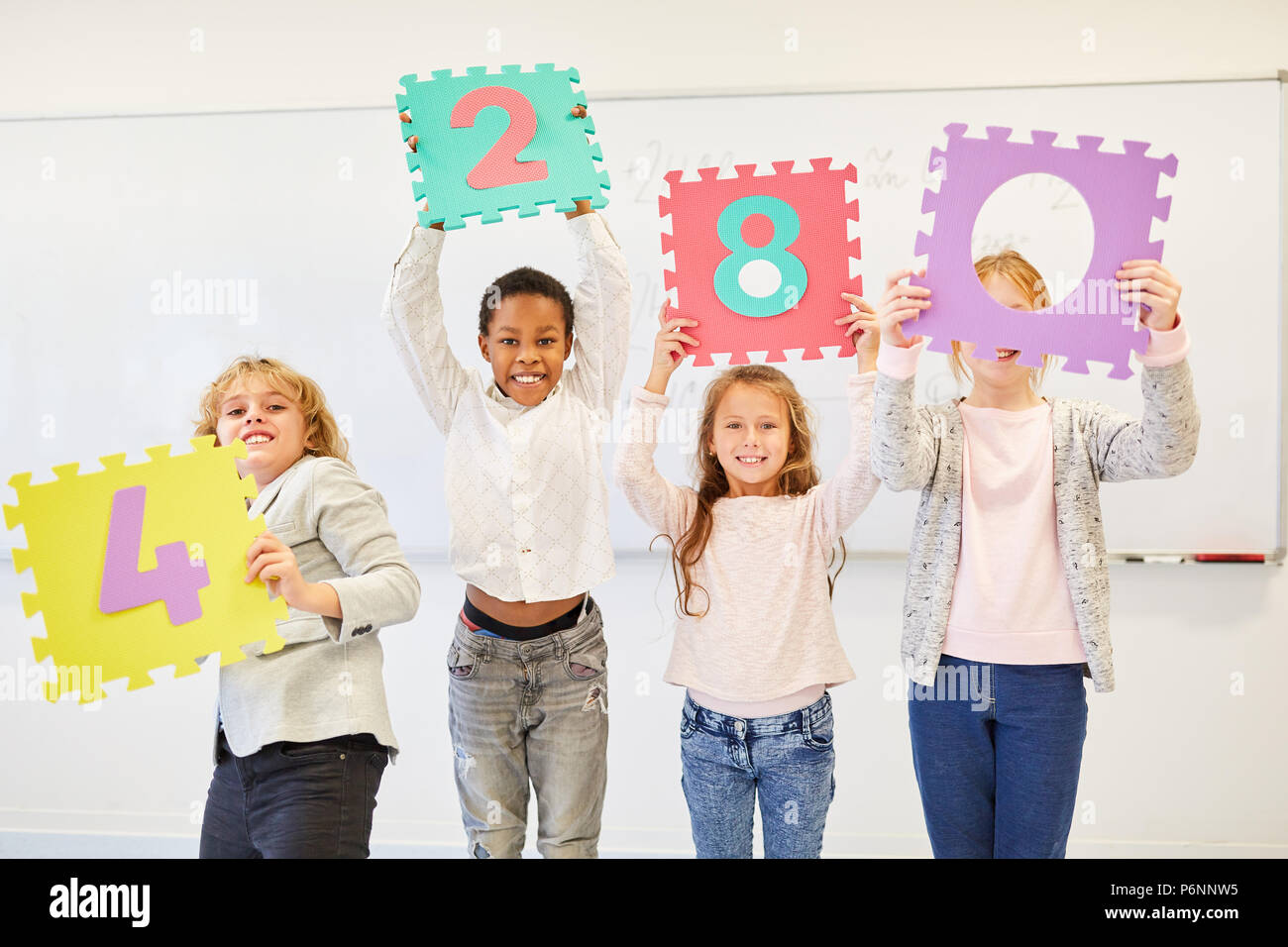 Les enfants jouent dans un exercice pour le développement de l'équipe créative avec des nombres Banque D'Images