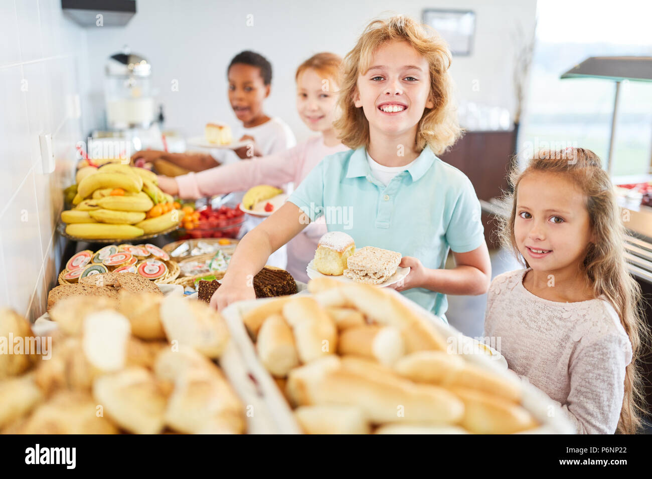 Les élèves à l'école primaire prendre fruit au buffet dans la cafétéria Banque D'Images