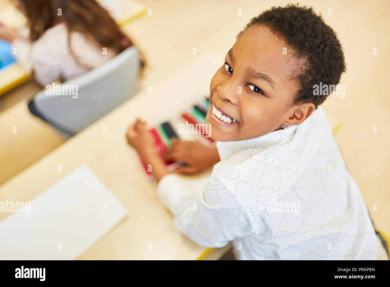 African boy comme un enfant d'âge préscolaire ou élémentaire étudiant est heureux dans la classe Banque D'Images