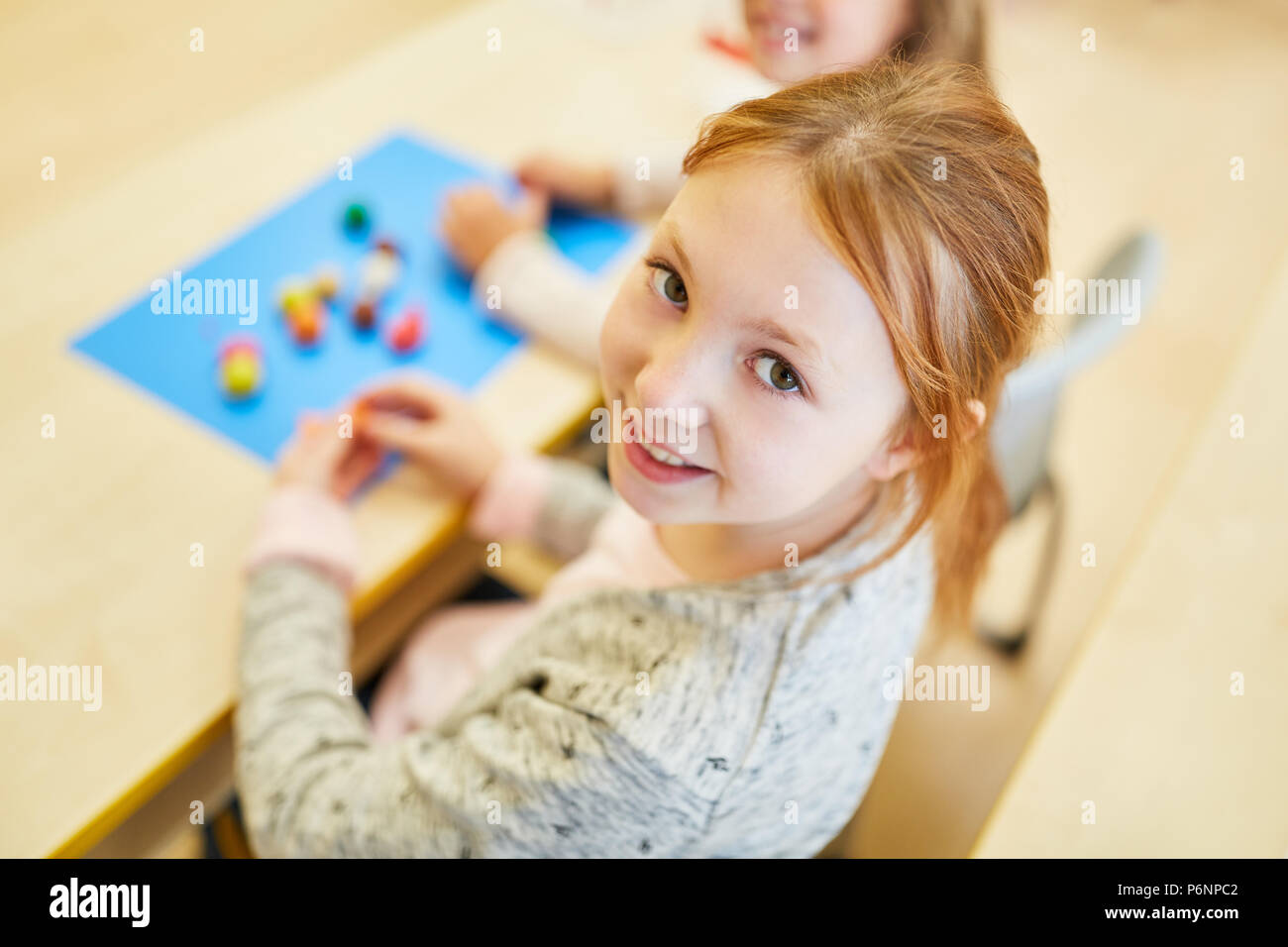 Smiling girl en maternelle ou l'école primaire à un jeu Banque D'Images
