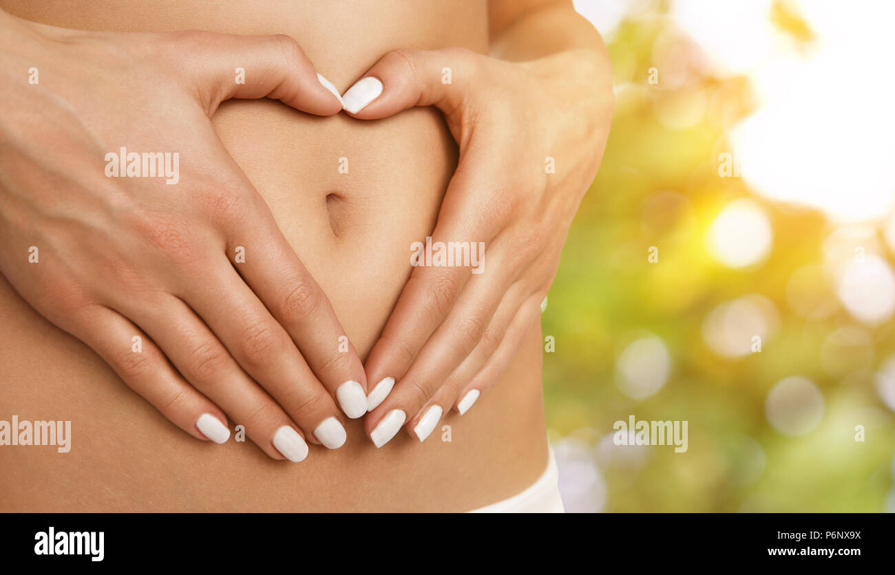 Soins du corps, la grossesse ou l'alimentation concept, femme mains formant  forme de cœur sur l'estomac Photo Stock - Alamy