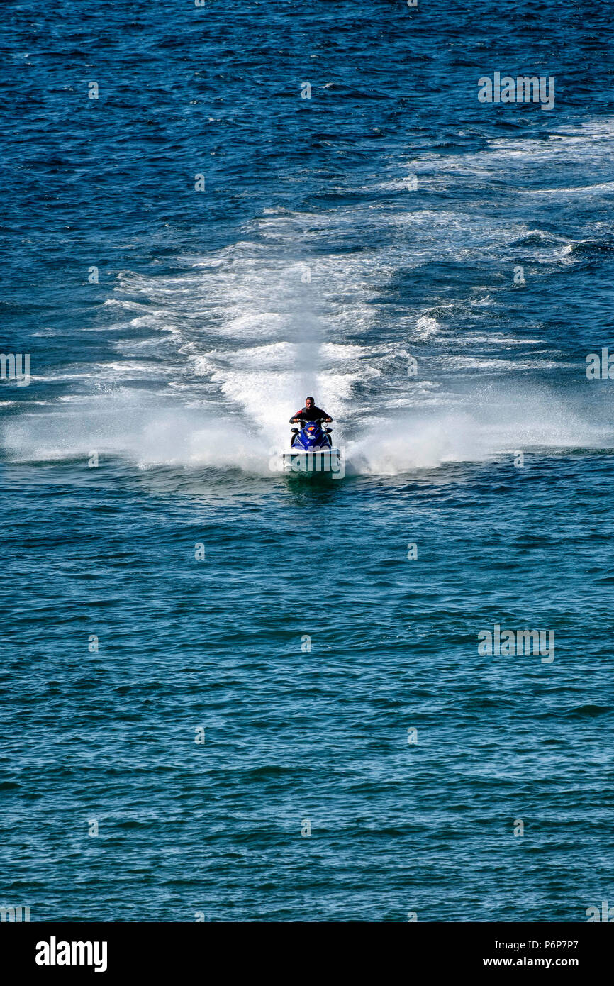 Un homme sur une moto jet bénéficie du temps au large de la côte nord du Devon Le près de Ilfracombe quand la température continue de monter à travers le Royaume-Uni. Banque D'Images