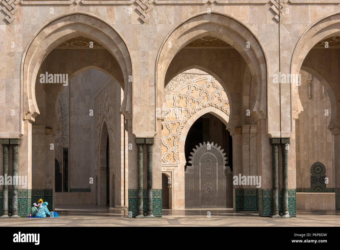 Famille installÃ©e pour une pause dominicale au piede la colonade du pÃ©ristyle de la MosquÃ©e Hassan II. Casablanca, Maroc. Banque D'Images