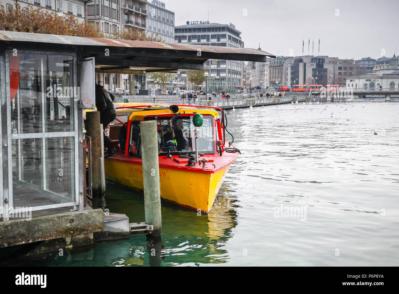 Genève, Suisse - le 26 novembre 2016 : les passagers au chargement sur le bateau. L'une des mouettes, les petits taxis jaunes sur le lac de Genève Banque D'Images