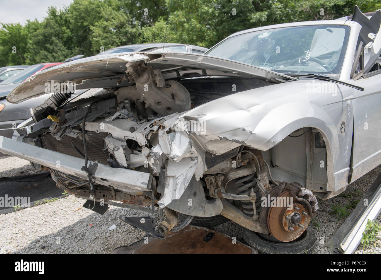 Avant d'une voiture accidentée dans une cour de récupération, les roues enlevées, le corps détruit Banque D'Images
