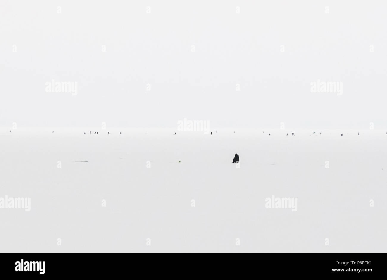 La pêche d'hiver sur le lac glacé, fond naturel. Vue aérienne panoramique de style minimaliste. Des tons noir et blanc dans la photographie minimaliste. Banque D'Images