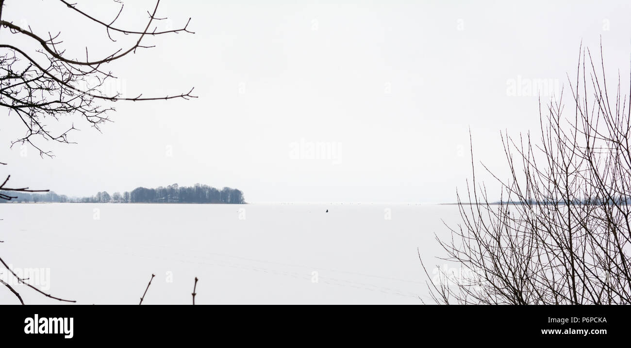 La pêche d'hiver sur le lac glacé, fond naturel. Vue aérienne panoramique de style minimaliste. Des tons noir et blanc dans la photographie minimaliste. Banque D'Images