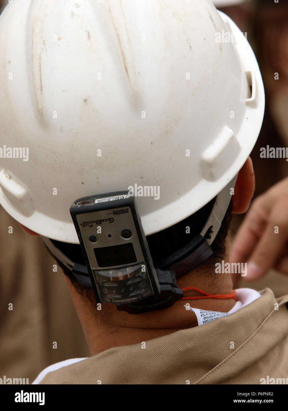 Les travailleurs du pétrole fixer un détecteur de gaz, de leur casque d'être alerte et sûr pour le travail autour des puits. Banque D'Images