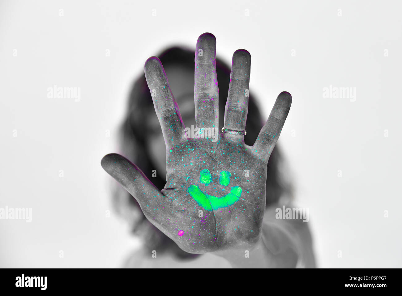L'auto-portraite avec néon et de lumières uv pour rendre l'éclat de peinture. Arrêter et sourire. portrait créatif colorés d'une jeune femme. Banque D'Images