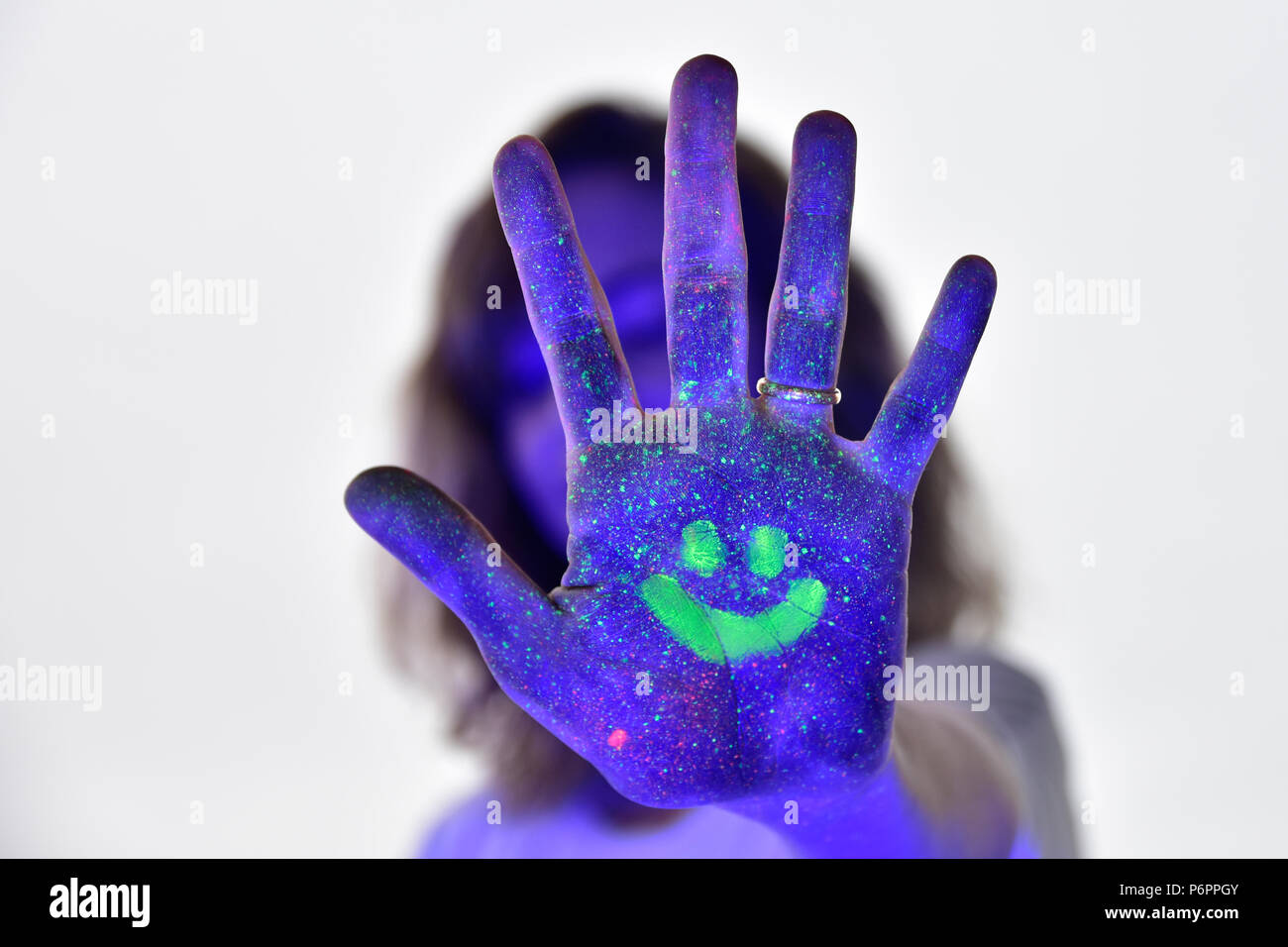 L'auto-portraite avec néon et de lumières uv pour rendre l'éclat de peinture. Arrêter et sourire. portrait créatif colorés d'une jeune femme. Banque D'Images