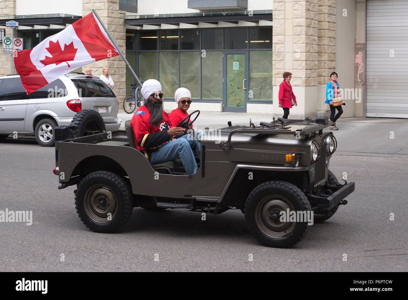 Calgary, Canada. 1er juillet 2018. Les célébrants de la fête du Canada se trouvent dans une rue du quartier eau Claire, au centre-ville de Calgary, avec un drapeau canadien. Rosanne Tackaberry/Alamy Live News. Banque D'Images