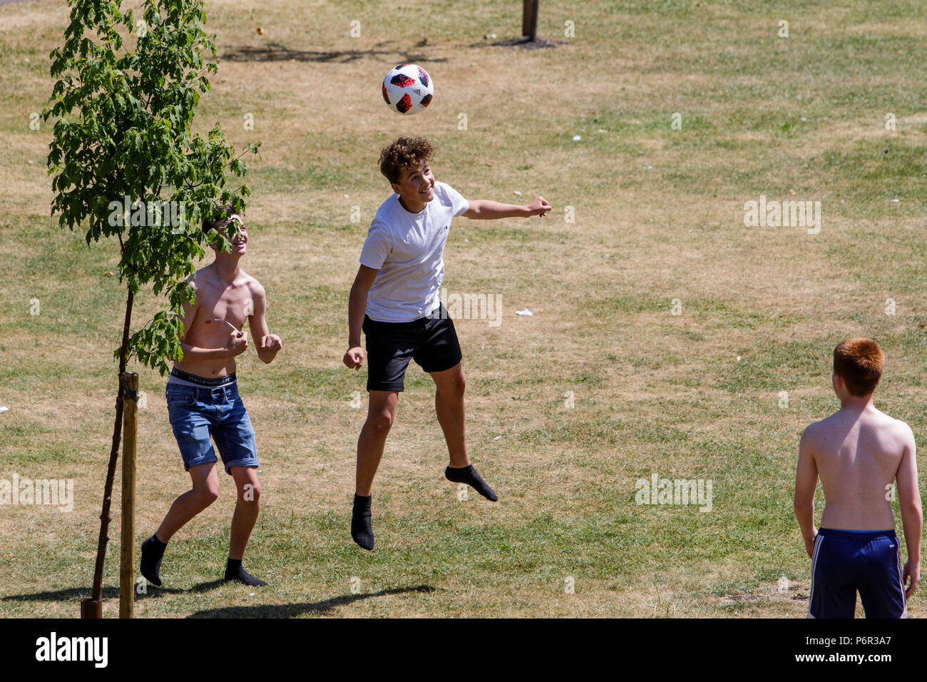 Bath, Royaume-Uni, 2 juillet 2018. Que le Royaume-Uni bénéficie d'une autre journée très chaude et ensoleillée, un groupe de jeunes hommes sont représentés comme ils kick a football autour de jardins dans le défilé, les prévisionnistes prévoient que le temps chaud qui se poursuivra jusqu'à la semaine prochaine. Banque D'Images