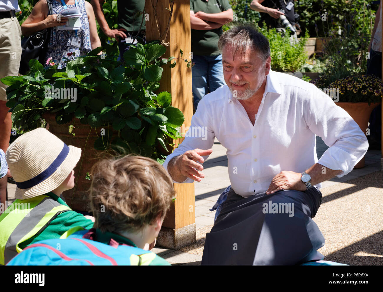 RHS Hampton Court Palace Flower Show, le 2 juillet 2018. Raymond Blanc propriétaire et chef de Le Manoir aux Quat' Saisons l'enseignement aux enfants au sujet de l'alimentation. P Crédit Tomlins/Alamy Live News Banque D'Images