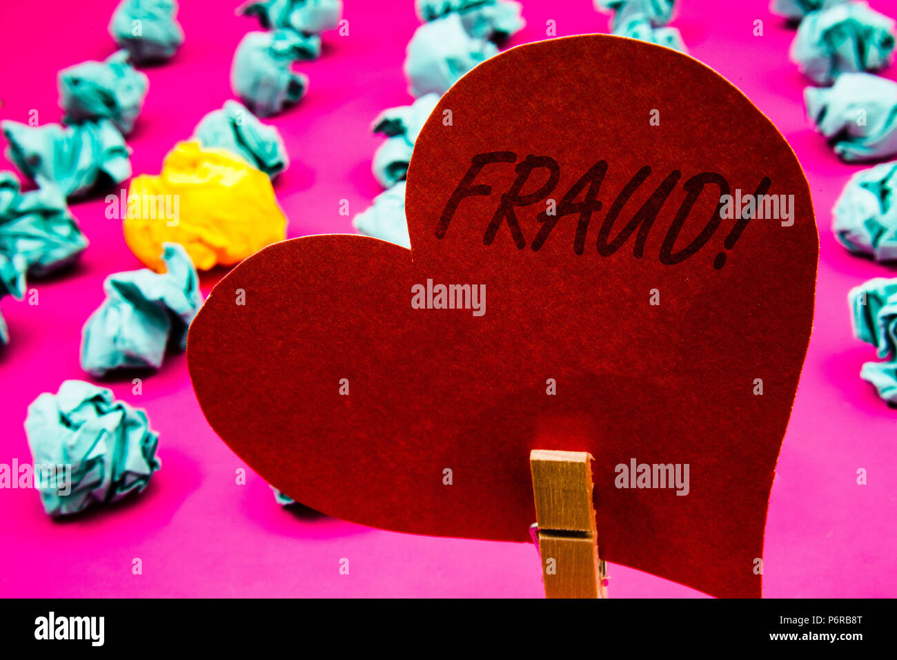 Texte de l'écriture de la motivation de la fraude téléphonique. La tromperie criminelle signification du concept d'obtenir des gains personnels ou financiers Clothespin holding red heart paper crum Banque D'Images