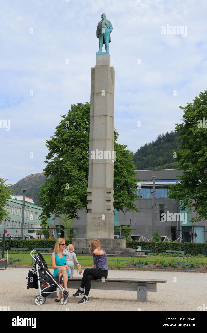 Deux femmes et un enfant s'asseoir sur un banc en face de la statue de Christian Michelsen à Bergen, Norvège Banque D'Images