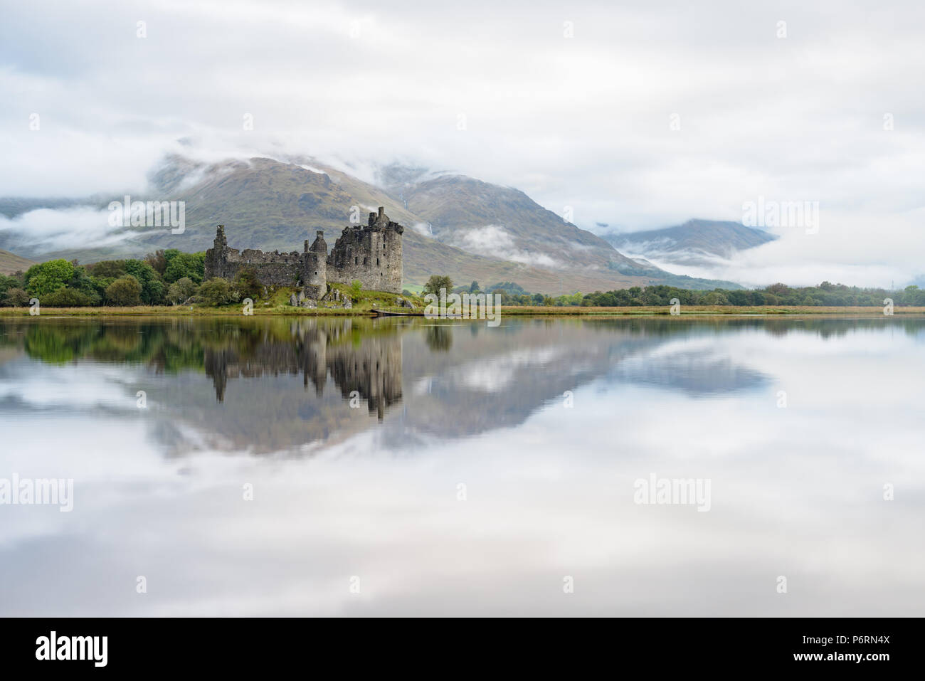 Réflexions de Kilchurn Castle à Argyll and Bute, Ecosse, dans les eaux calmes du Loch Awe et entourée de collines de la bruine de Cruachan Banque D'Images