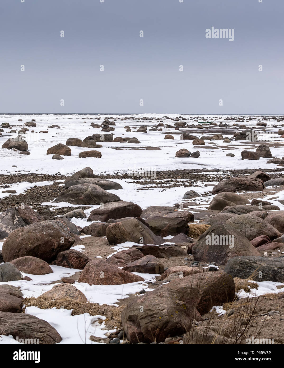 Les rochers et la neige sur la neige de la mer Baltique gelée sous le ciel bleu de sordide froid Mersrags, Lettonie Banque D'Images