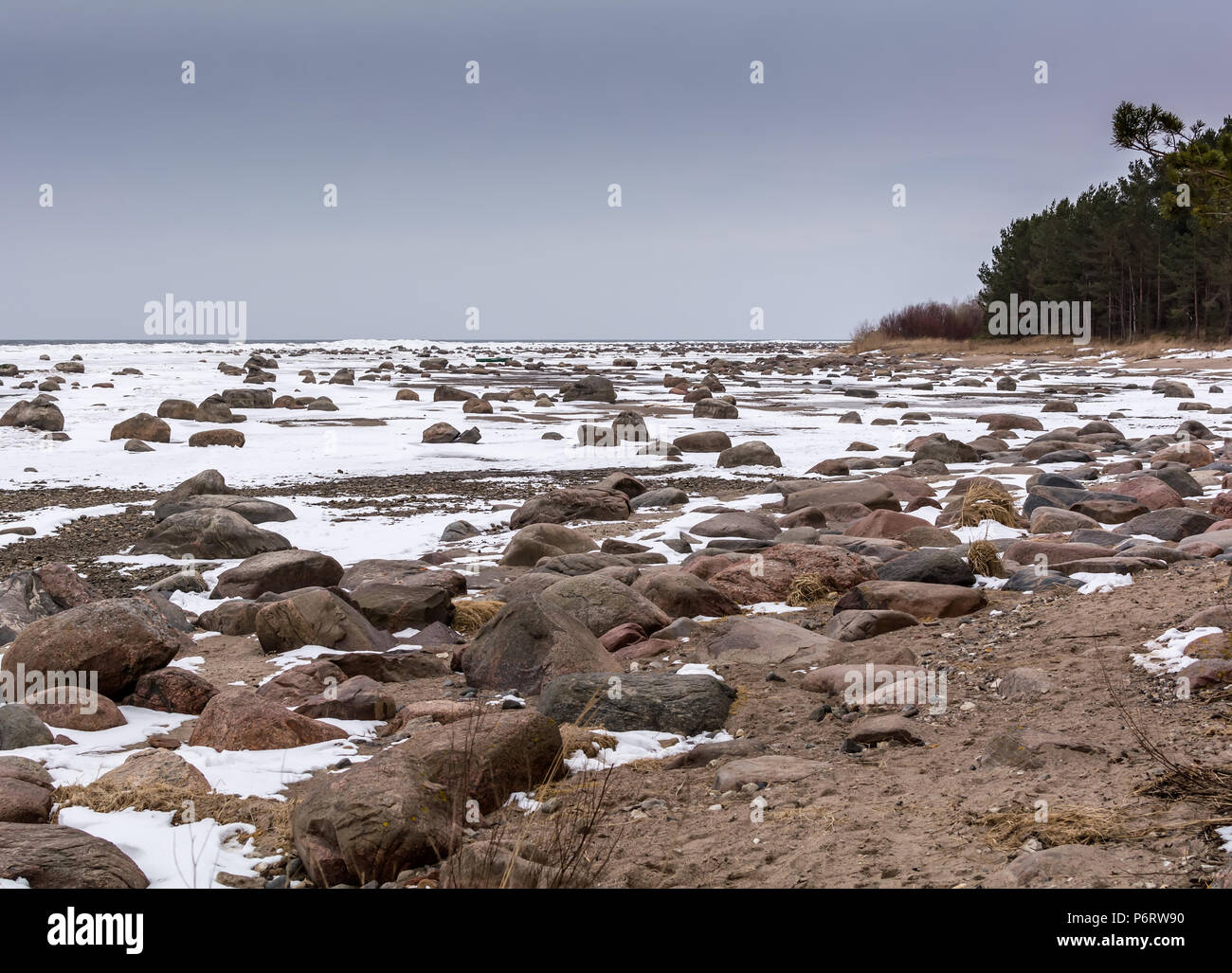 Les rochers et la neige sur la neige de la mer Baltique gelée sous le ciel bleu de sordide froid Mersrags, Lettonie Banque D'Images