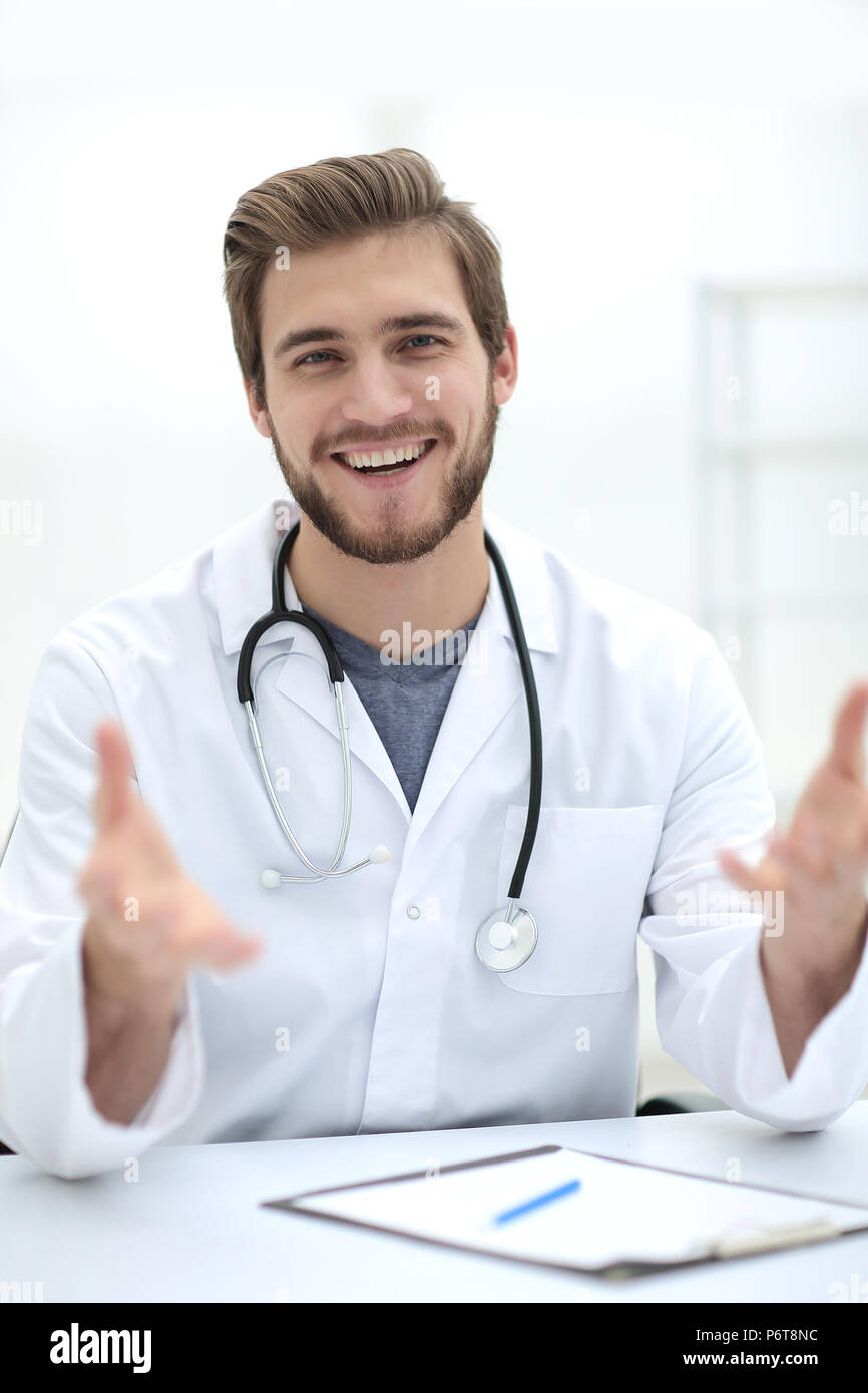 Beau médecin en blouse blanche offre sa main Banque D'Images