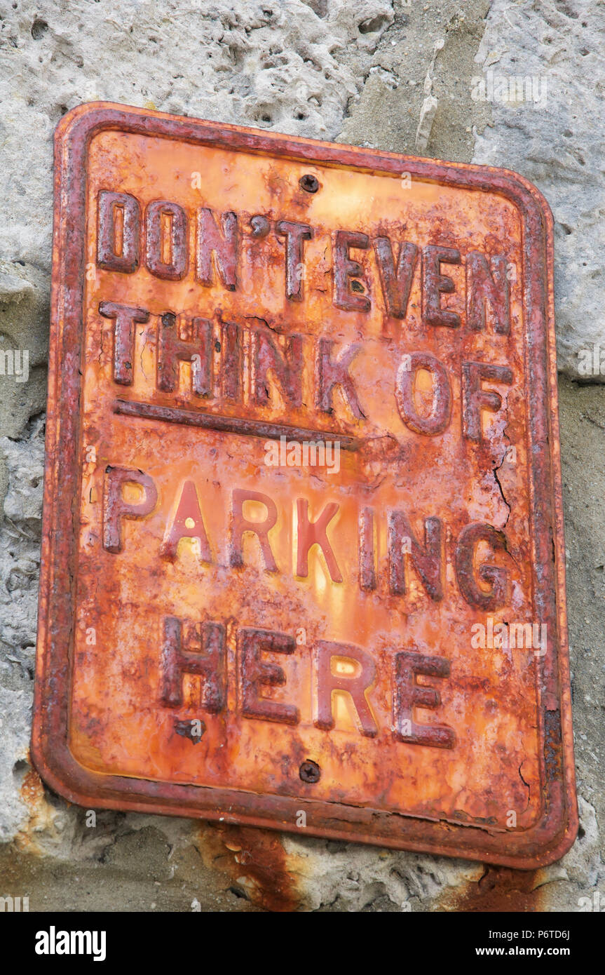 "Ne pense même pas de parking ici". Pas de parking d'humour message sur une texture de métal rouillé vieux signe. Île de Portland, Dorset, Angleterre, Royaume-Uni. Banque D'Images