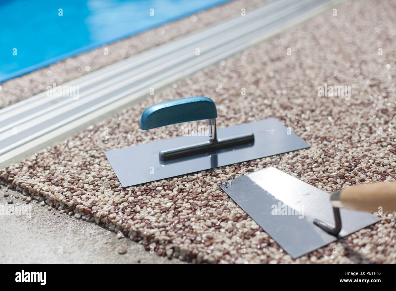 Béton coloré autour de la piscine avec des outils Banque D'Images