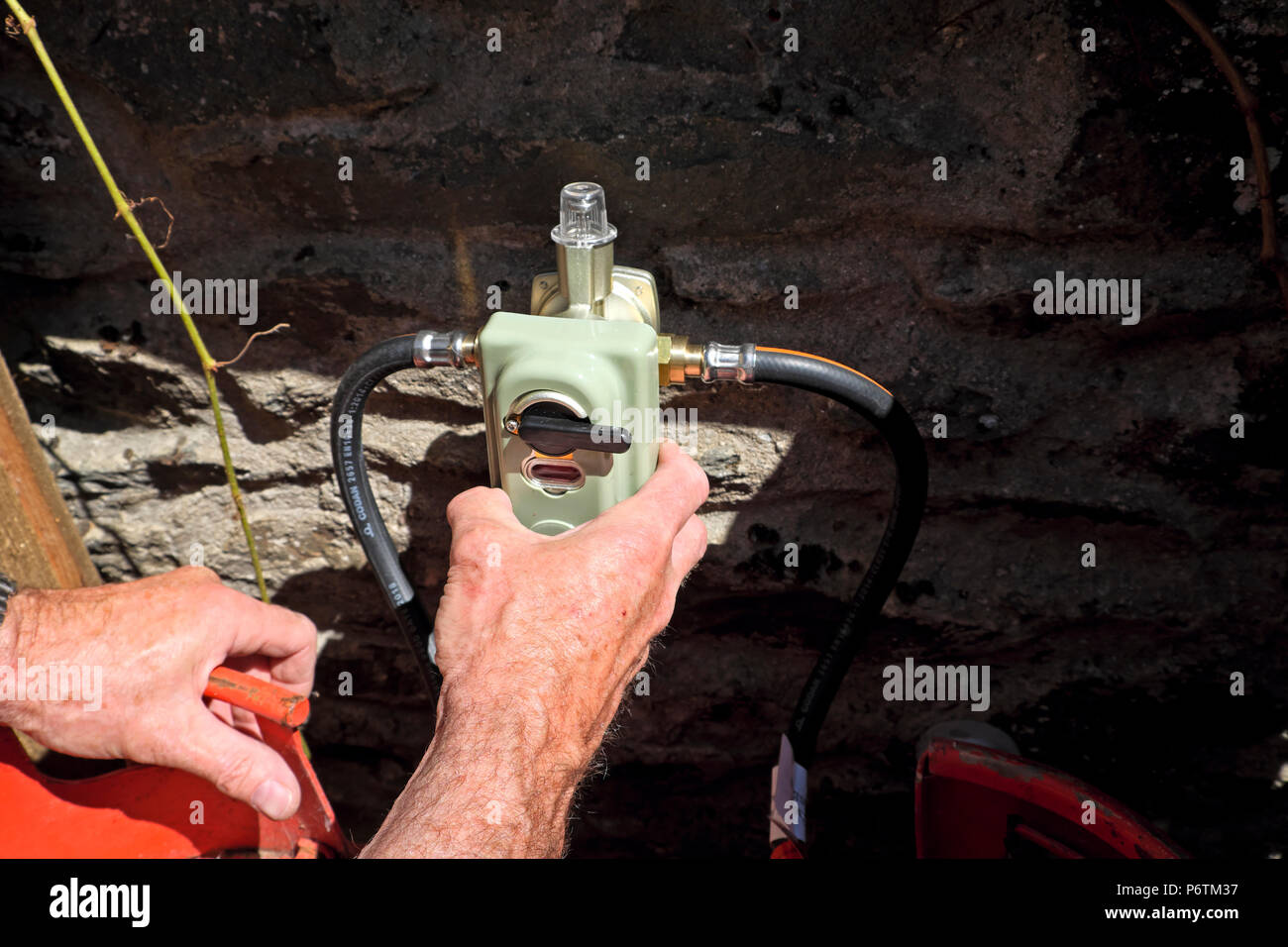 Mécanicien d'un montage d'une vanne d'inversion 2 pack avec plus d'arrêt de pression de bouteilles de gaz GPL carburant qu'une cuisinière à gaz dans les régions rurales du pays de Galles UK KATHY DEWITT Banque D'Images