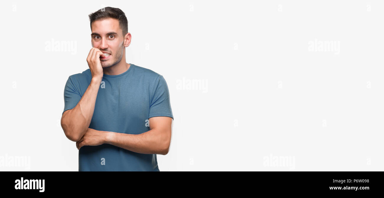 Beau jeune homme à la recherche a souligné et nerveux avec les mains sur la bouche de mordre les ongles. Problème d'anxiété. Banque D'Images
