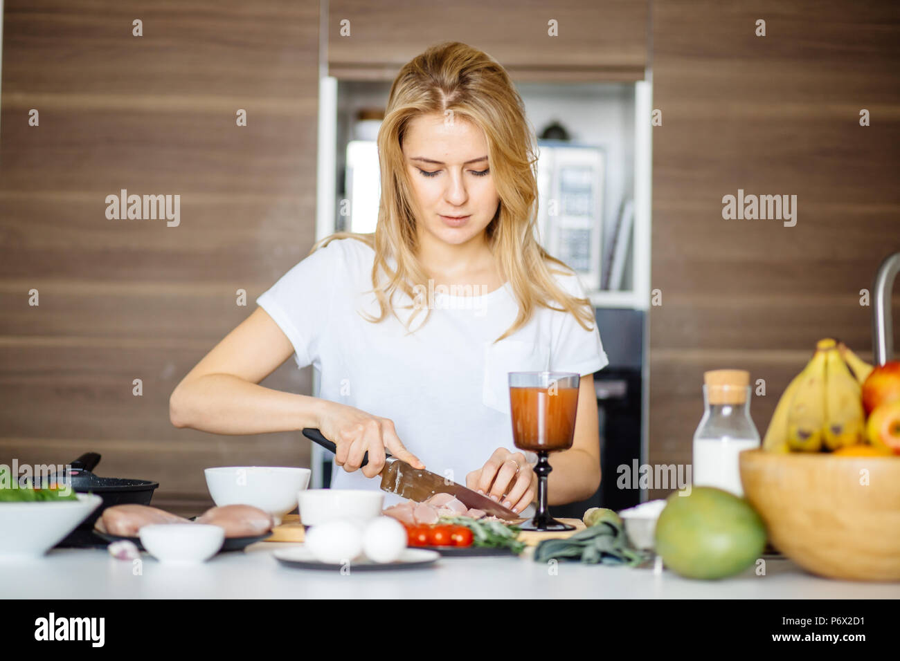 Woman slicing préparer la viande viande kebab sur une table de cuisine avec un grand couteau Chef. Cook attrayant couper la viande sur la table se prépare à surprendre son boyfr Banque D'Images