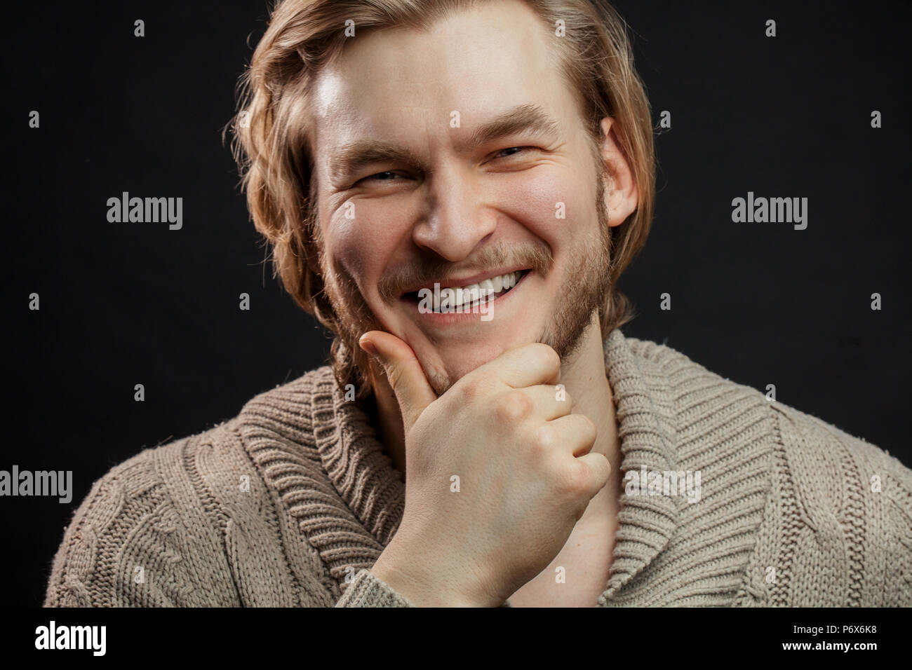 Cheerful businessman in casual clothers touchant son deard Banque D'Images