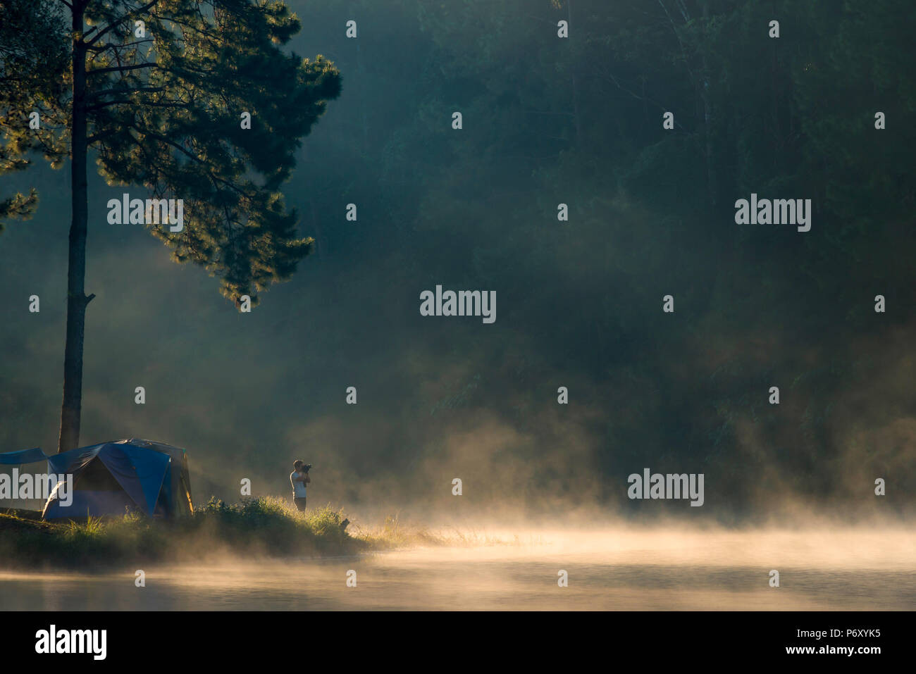 L'homme avec l'appareil photo est shoot à Pang Ung Lake, au nord de la Thaïlande est un lieu touristique où les gens viennent pour des vacances dans l'hiver Banque D'Images