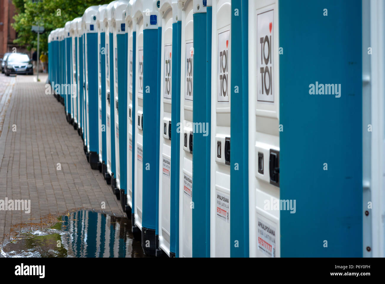 RIGA, Lettonie - 22 juin 2018 : marché du solstice d'été. Sur le bord de la rue de la ville il y a une ligne avec des toilettes publiques. Banque D'Images