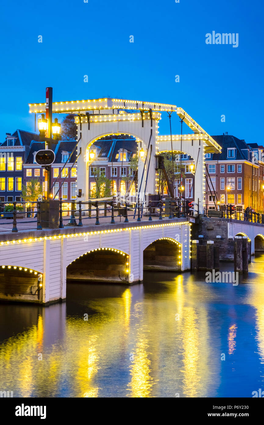 Pays-bas, Amsterdam, Hollande du Nord. Pont Magere Brug, maigres, sur la rivière Amstel la nuit. Banque D'Images