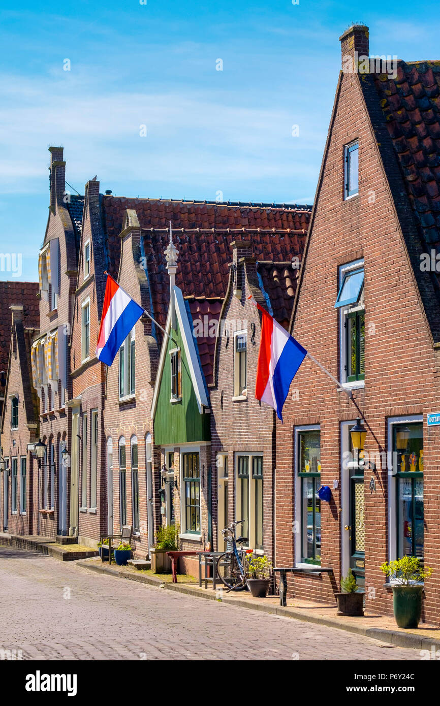 Pays Bas, Hollande du Nord, Edam. Maisons en briques avec drapeaux néerlandais étendus dehors pour la fête nationale. Banque D'Images