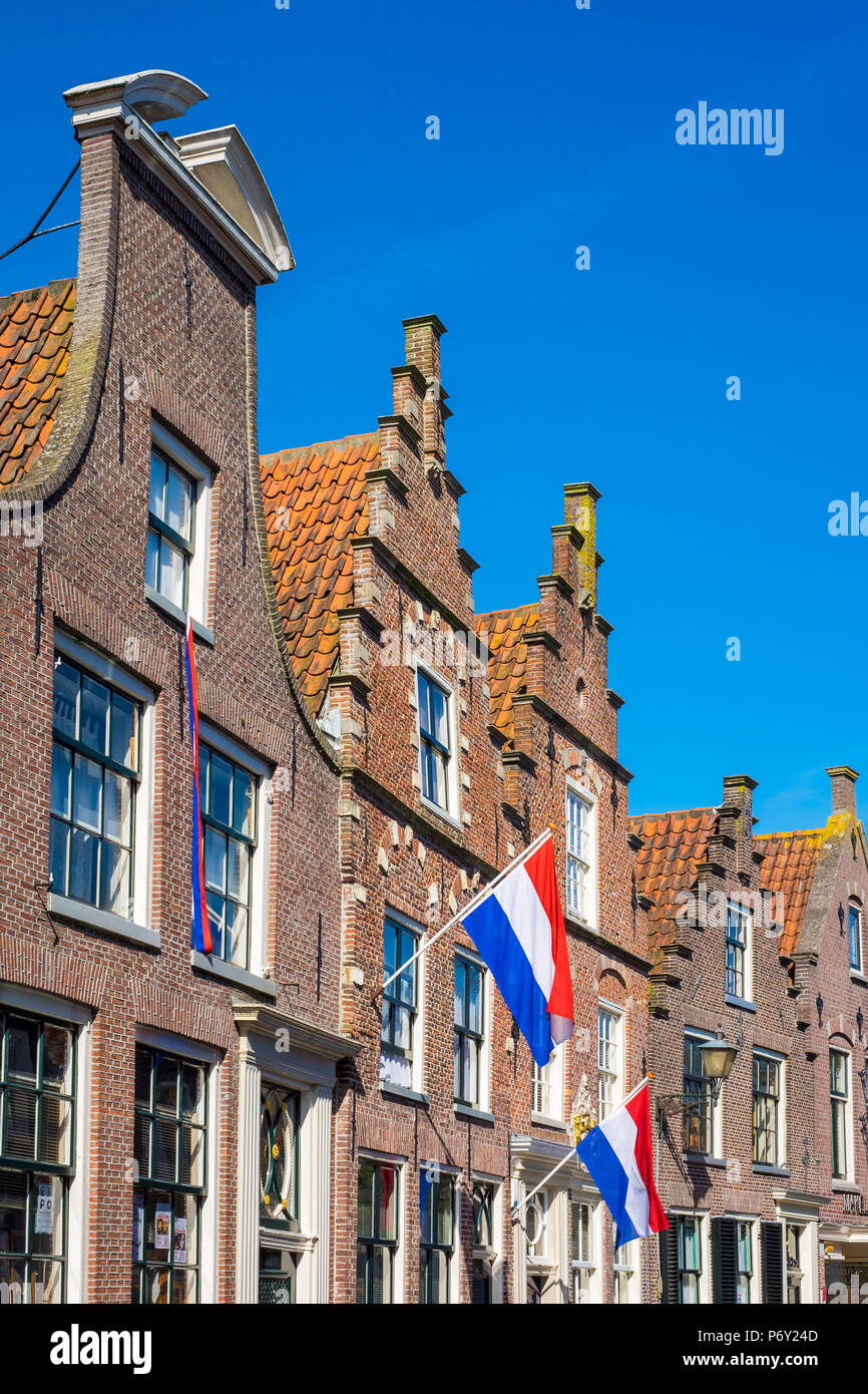 Pays Bas, Hollande du Nord, Edam. Maisons en briques avec drapeaux néerlandais étendus dehors pour la fête nationale. Banque D'Images