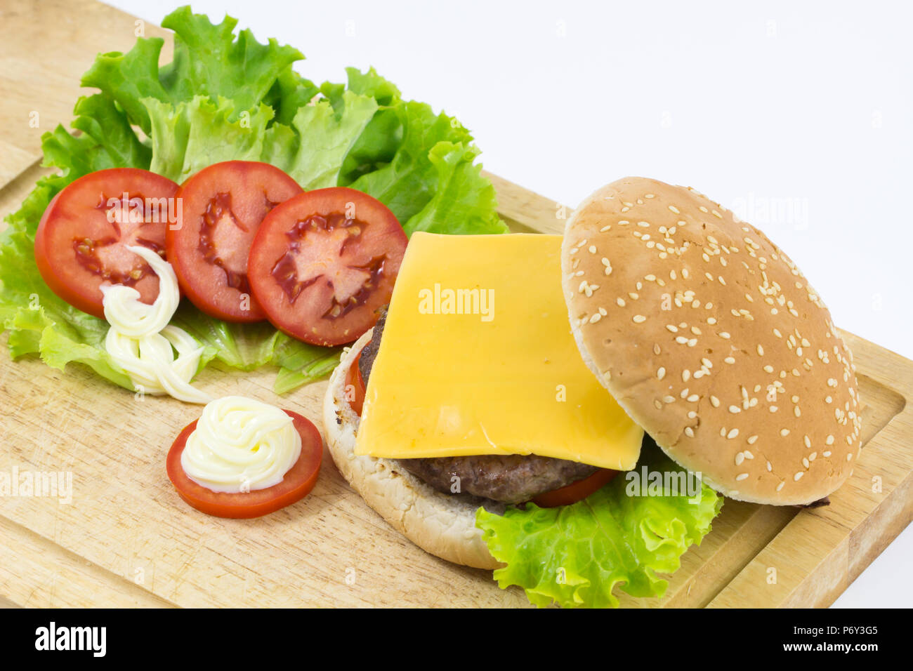 Hamburger fait maison avec salade, tomate, fromage, viande de boeuf et frites placés sur fond de bois , frais délicieux burger, d'arrière-plan Banque D'Images