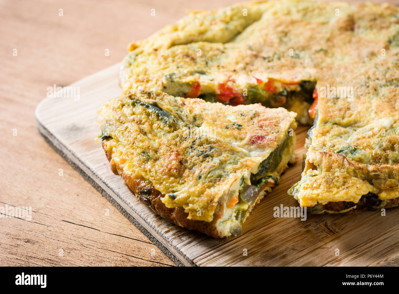Faites de la frittata des œufs et des légumes sur la table en bois. Banque D'Images