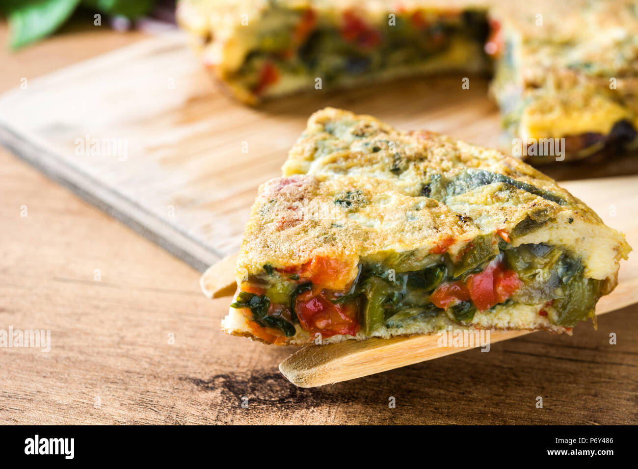 Faites de la frittata des œufs et des légumes sur la table en bois. Banque D'Images