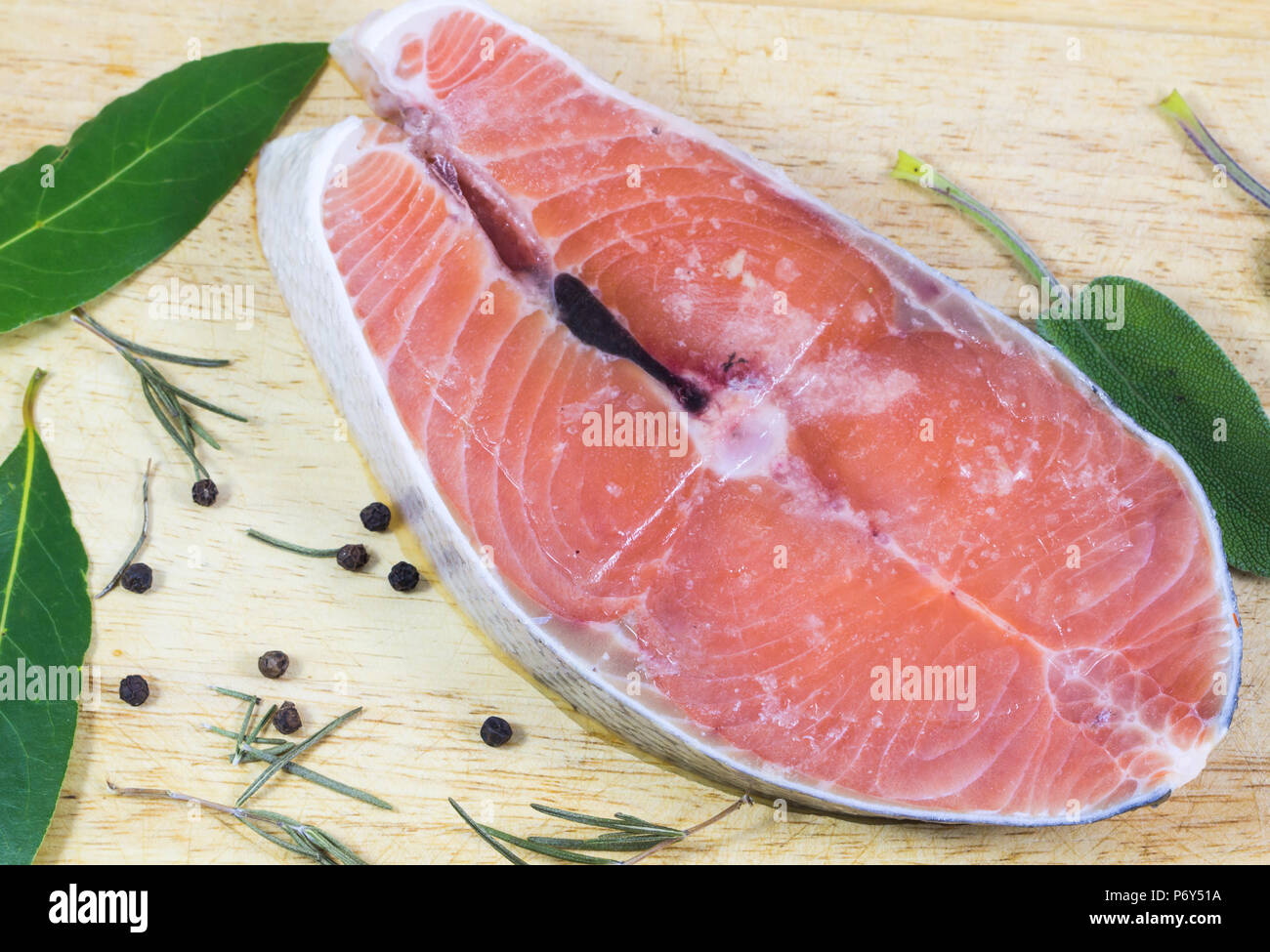 Tranches de saumon congelés sur fond de bois. Banque D'Images